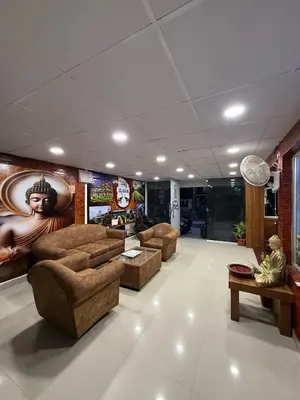 a living room with couches and a painting on the wall at Siddhartha Residency in Mysore
