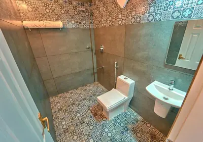 a bathroom with a toilet and a sink at Gardenia Pool Resort Kanthalloor by VOYE HOMES Mountain View Stay Near Bhramaram view Point in Kanthalloor