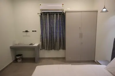 a bedroom with a cabinet and a sink and a desk at Castle DAK in Trichūr