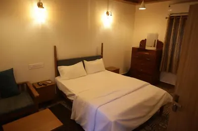 a small bedroom with a bed and a chair at Castle DAK in Trichūr
