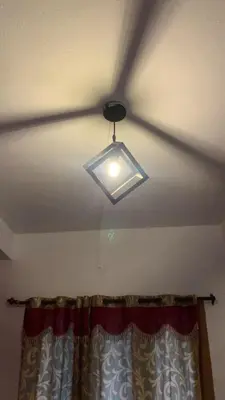 a ceiling fan with a light in a room at DADIL HOME STAY ooty in Ooty