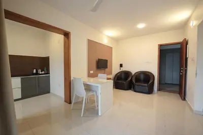 a living room with a table and chairs in a room at Mirage Luxuria Inn in Vythiri
