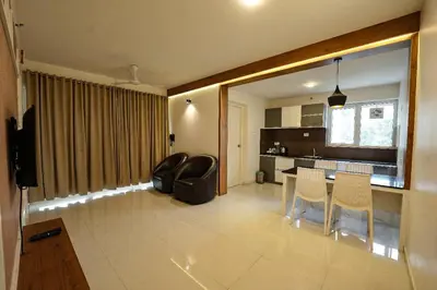 a kitchen and living room with a table and chairs at Mirage Luxuria Inn in Vythiri