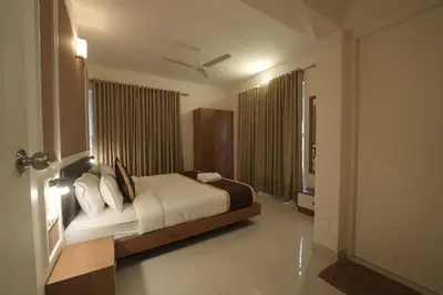 a bedroom with a bed and a large window at Mirage Luxuria Inn in Vythiri