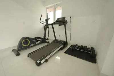 a gym with a treadmill and a phone in a room at Mirage Luxuria Inn in Vythiri