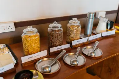 a counter with four spoons and jars of food at Discovery Village Kabini in Antarasante