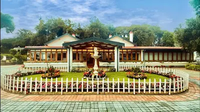 a building with a flower garden in front of it at Milntown Bungalow 200 years old Colonial Stay in Coonoor in Coonoor