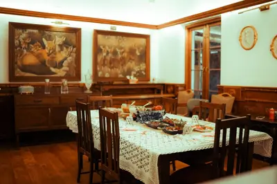 a dining room with a table with a white table cloth at Milntown Bungalow 200 years old Colonial Stay in Coonoor in Coonoor