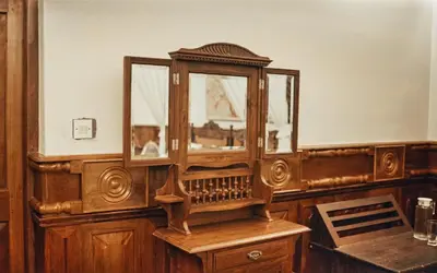 a wooden cabinet with a mirror on top of a table at Milntown Bungalow 200 years old Colonial Stay in Coonoor in Coonoor