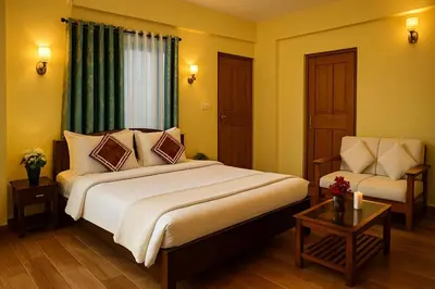 a hotel room with a large bed and a chair at Dreamview Cottage by BEN Groups in Ooty