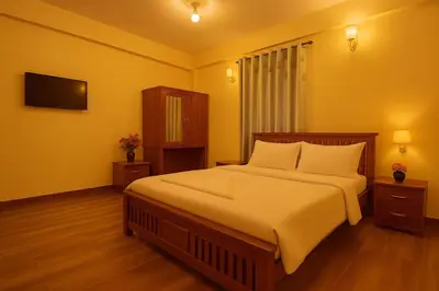 a bedroom with a large bed and a television at Dreamview Cottage by BEN Groups in Ooty