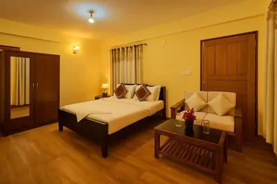 a hotel room with a bed and a table at Dreamview Cottage by BEN Groups in Ooty
