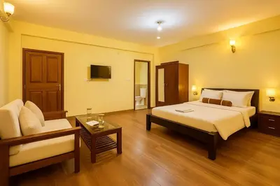 a bedroom with a bed and a couch and a chair at Dreamview Cottage by BEN Groups in Ooty