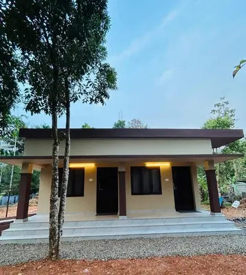 a house with two trees in front of it at Cosy Stays, 2 Adjacent Apartments in Irinjalakuda in Irinjālakuda
