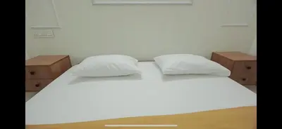 a white bed with two pillows on top of it at AZURE stay happy in Pudunagaram
