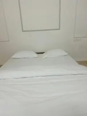 a white bed with two pillows in a room at AZURE stay happy in Pudunagaram