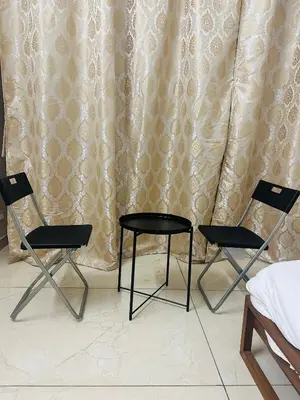 two chairs and a table in front of a curtain at AZURE stay happy in Pudunagaram