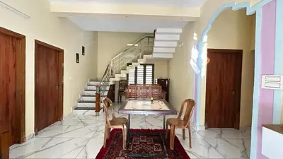 a dining room with a table and chairs and stairs at Hima Pool Villa in Padinjarathara