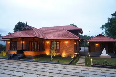 a small house with a statue in front of it at Serene Cottage - Home away from Home in Vythiri