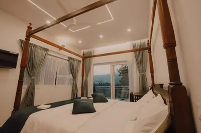 a bedroom with a canopy bed in front of a window at SUKOON Stays - Nestled among the misty hills and lush forests in Vythiri