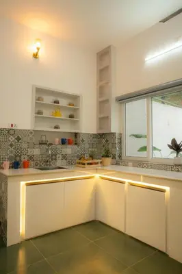 a kitchen with white counters and a window at SUKOON Stays - Nestled among the misty hills and lush forests in Vythiri