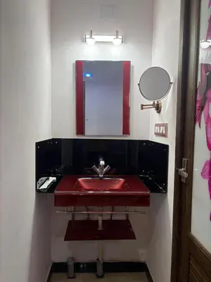 a bathroom with a red sink and a mirror at Forever Cottage by sait's hospitality in Ooty
