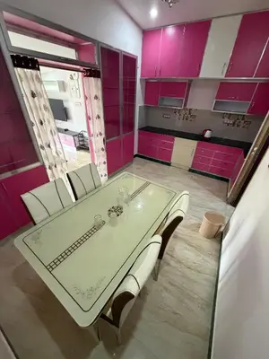 a dining room with pink cabinets and a table and chairs at Forever Cottage by sait's hospitality in Ooty