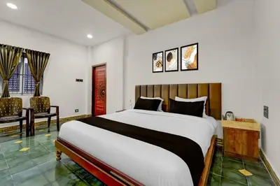 a bedroom with a large bed and a chair at Palette Mithalai Farm by CheckIn | Garden | Pvt Pool | Coimbatore in Coimbatore