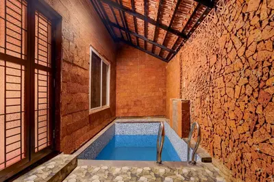 a swimming pool in a room with a brick wall at Palette Mithalai Farm by CheckIn | Garden | Pvt Pool | Coimbatore in Coimbatore