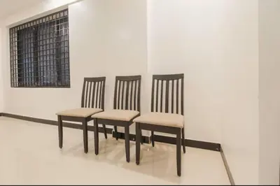 four chairs sitting in a row in a room at Sakthi Grand in Erode