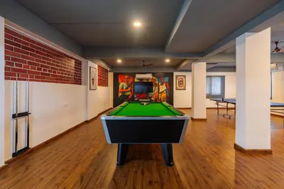 a room with a pool table in the middle of it at Everest Serenity Service Apartment in Pīlamedu