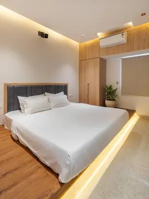 a bedroom with a large white bed and a tv at Everest Serenity Service Apartment in Pīlamedu