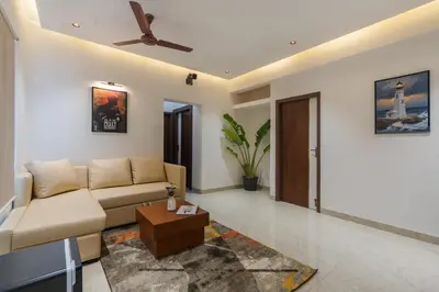 a living room with a couch and a ceiling fan at Everest Serenity Service Apartment in Pīlamedu