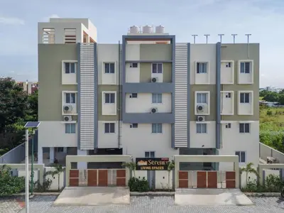 a tall white building with a sign in front of it at Everest Serenity Service Apartment in Pīlamedu