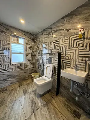 a bathroom with a toilet and a sink at Black Dot Stays - Mehand Veera Residency in Kodaikānāl