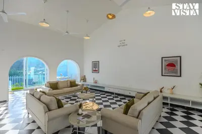 a living room with two couches and a checkered floor at StayVista at Mudra Tattva - Pvt Pool,Lawn,Jacuzzi 2BR Luxury Rooms in Suntikoppa