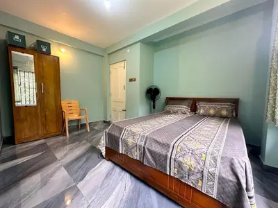a bedroom with a bed and a chair in it at Leaf links Coorg in Siddapur