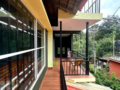 a balcony of a house with a view of the yard at Leaf links Coorg in Siddapur