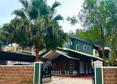 a palm tree in front of a building at Leaf links Coorg in Siddapur