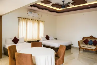 a room with two beds and a table and chairs at Blue Moon Homestay in Mysore