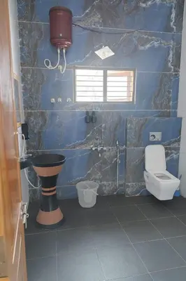 a blue bathroom with a toilet and a sink at Blue Moon Homestay in Mysore