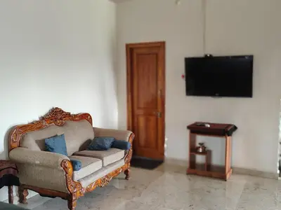 a living room with a chair and a flat screen tv at Blue Moon Homestay in Mysore