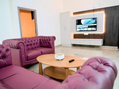 a living room with purple furniture and a tv at Amaira Studio living - Coimbatore in Coimbatore