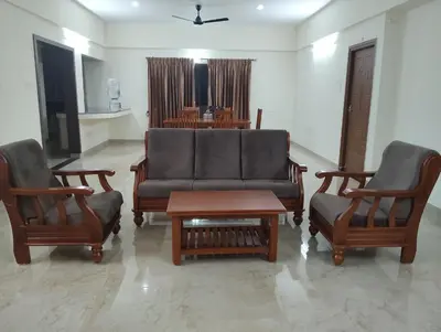 a living room with a couch and two chairs at Amaira Studio living - Coimbatore in Coimbatore