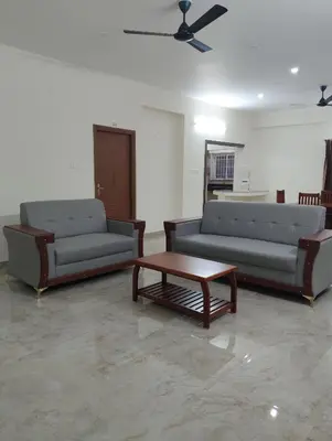 a living room with two couches and a coffee table at Amaira Studio living - Coimbatore in Coimbatore