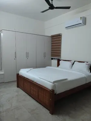 a bedroom with a large bed with a ceiling fan at Amaira Studio living - Coimbatore in Coimbatore