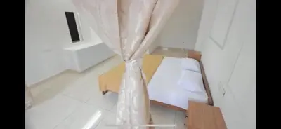 a bedroom with a bed with a curtain at AZURE stay happy in Pudunagaram