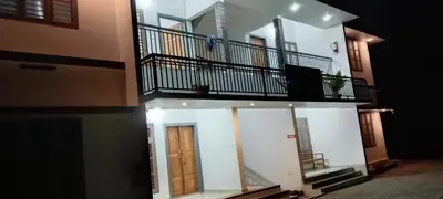 an apartment building with a balcony and a door at Green palace service villa in Kalpetta