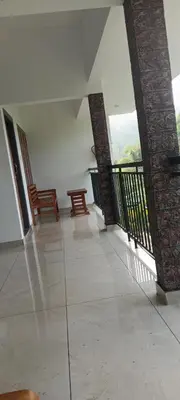 a room with two chairs and a balcony at Green palace service villa in Kalpetta