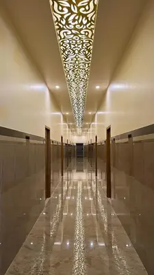 a hallway with a long hallway with a ceiling with lights at Estoria Hotel and Resort in Kadakola